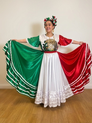 Dancer poses with a skirt of the Mexican flag.